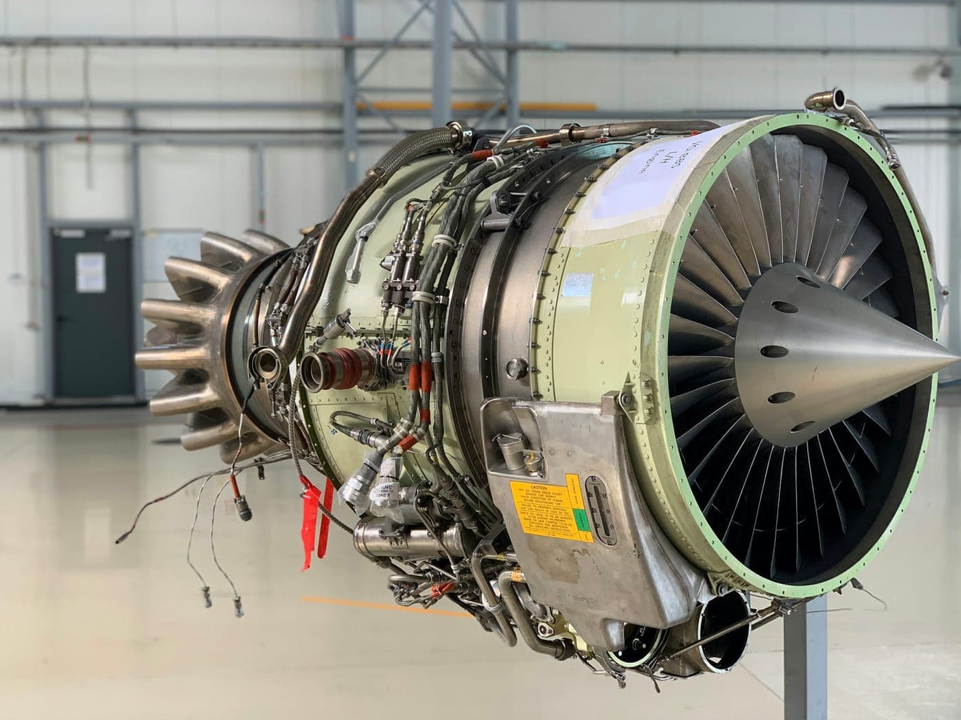A turbofan jet engine on a stand in a hangar