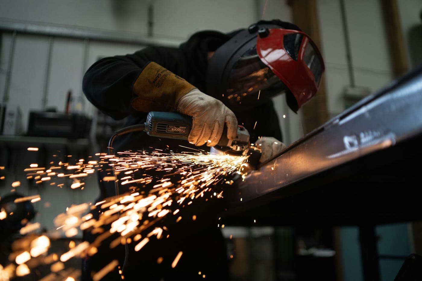A metalworker grinding steel, sparks flying