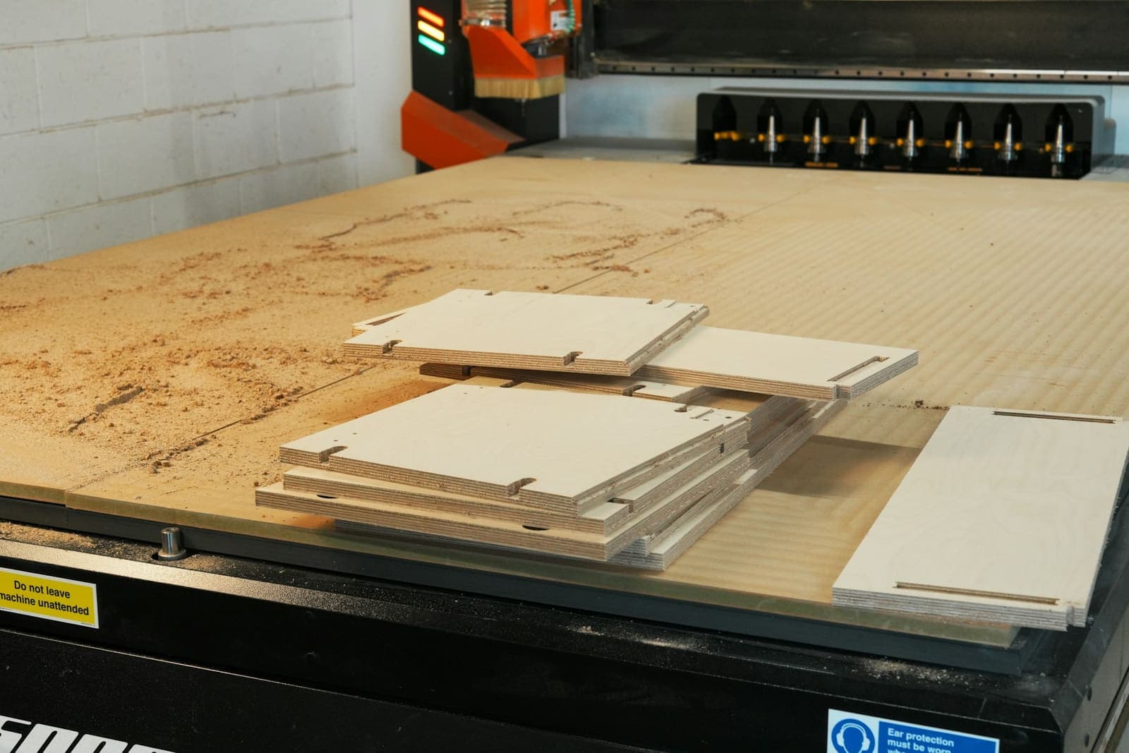 Cabinet panels stacked on the bed of a CNC router after cutting