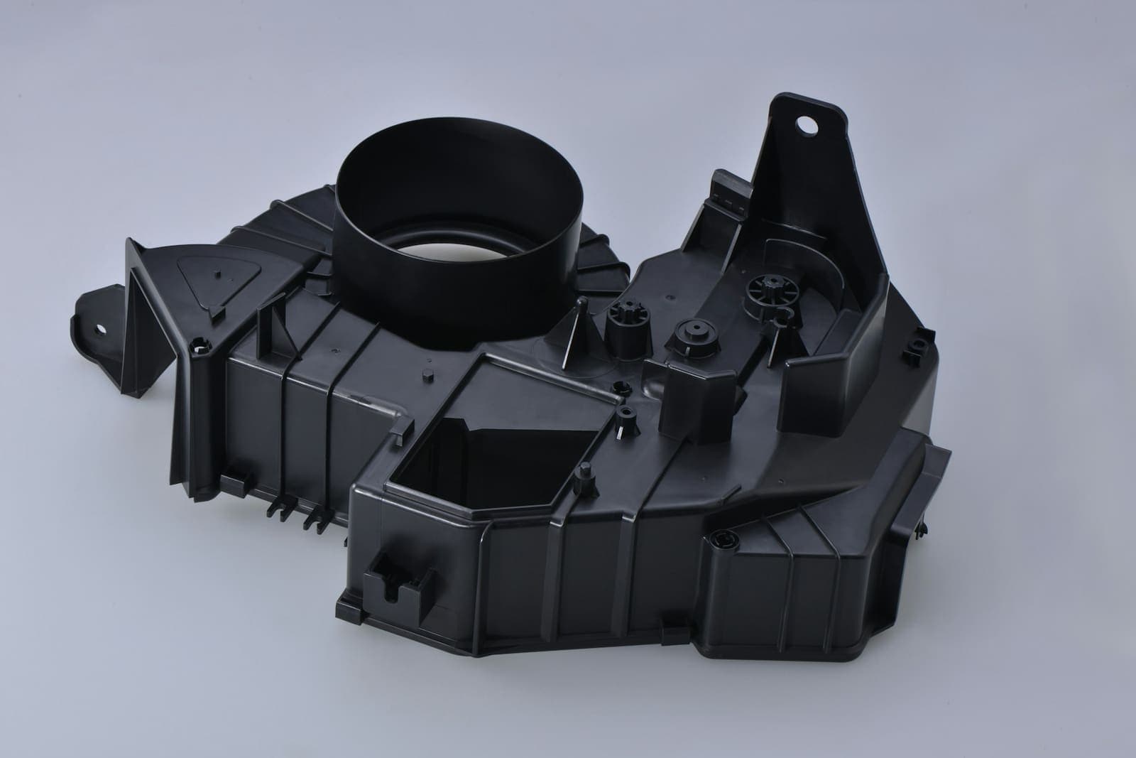 A black injection-moulded plastic housing on a white surface